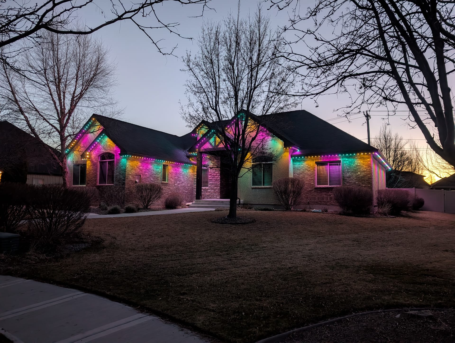 Year-round colorful permanent LED roofline lighting on Idaho Falls home exterior
