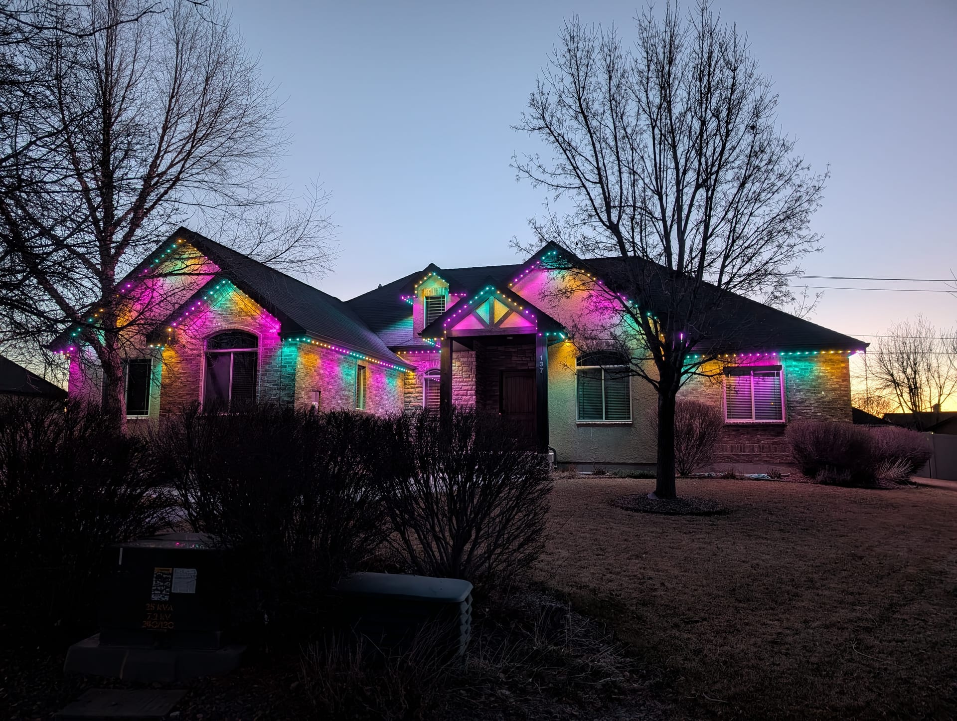 Multicolor permanent LED holiday lighting on Idaho Falls home roofline