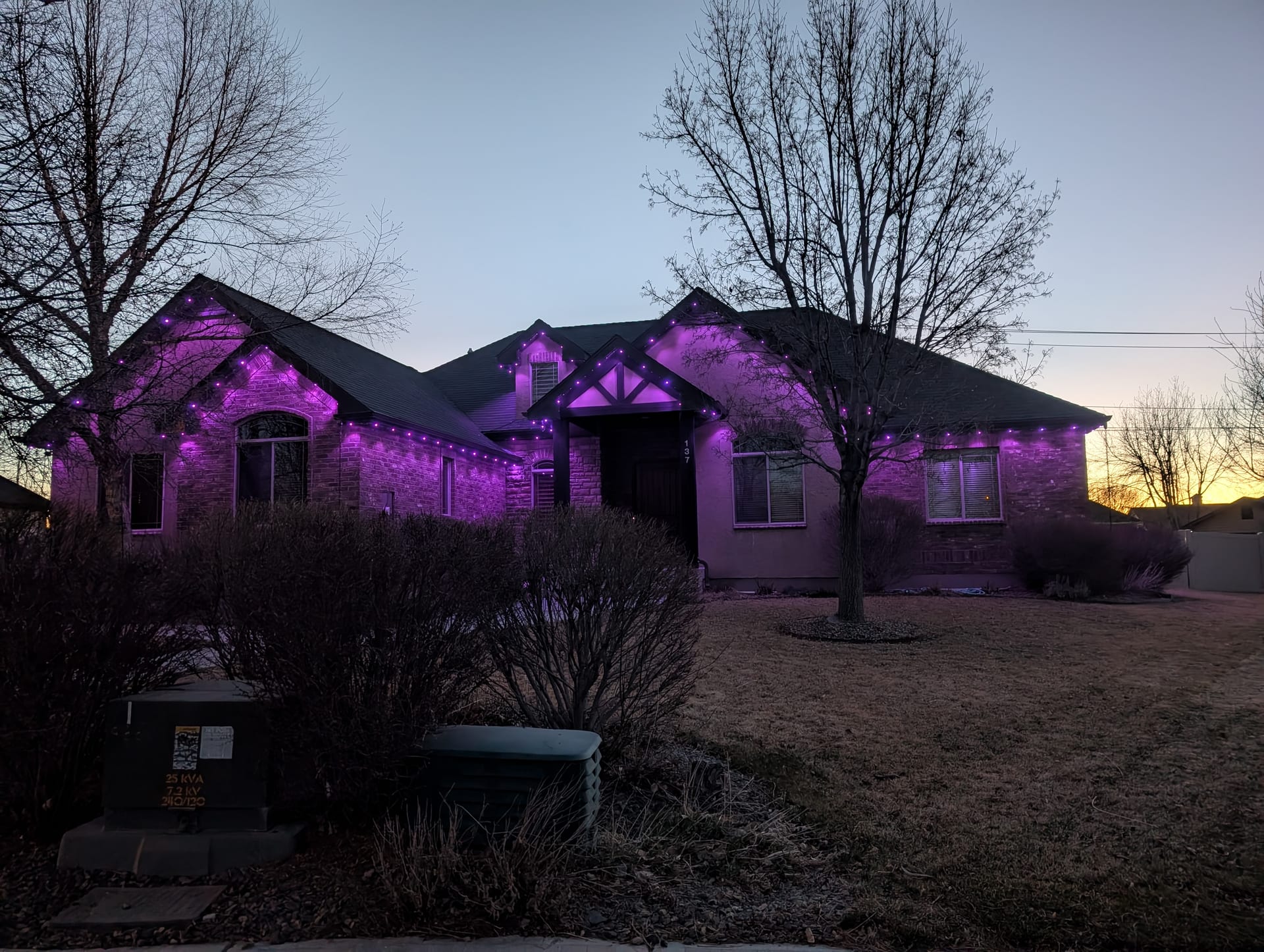 Purple permanent LED trim lights on brick ranch home roofline - ShowHome exterior lighting