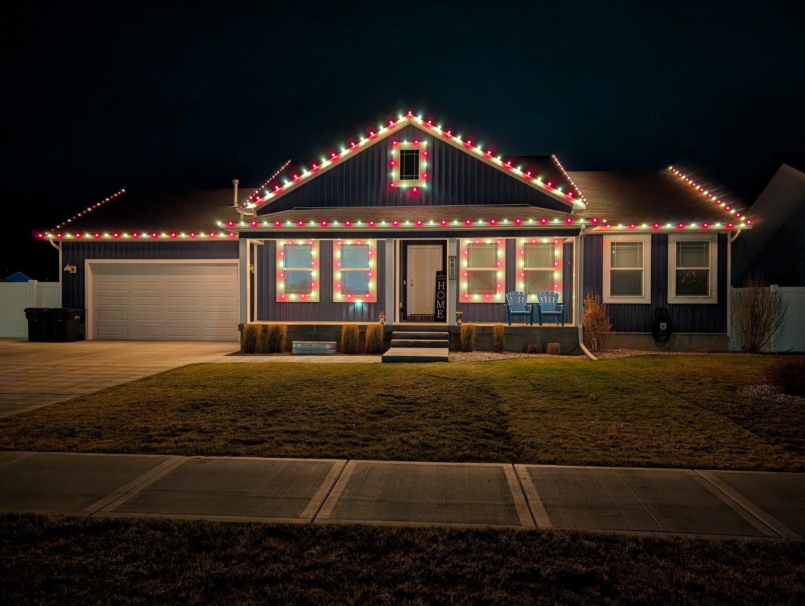 Red and white traditional Christmas lights outlining roofline and windows
