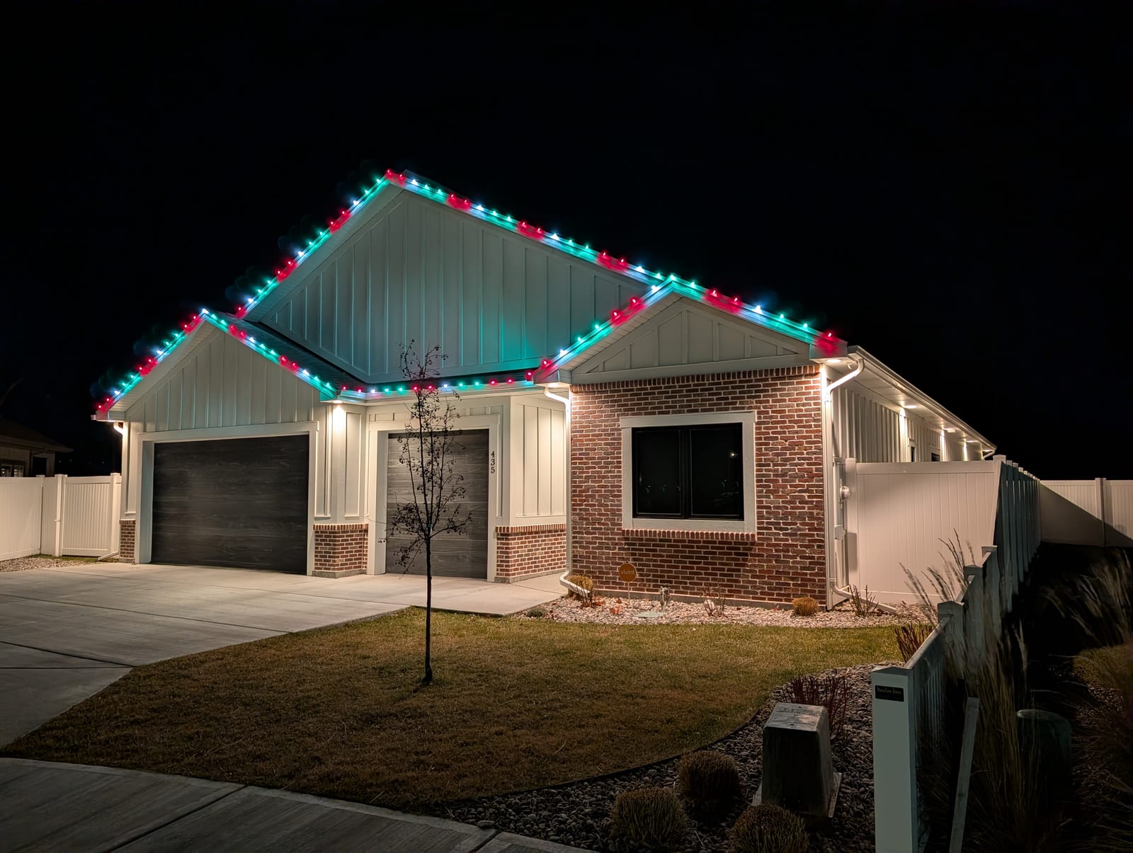 Teal and red traditional Christmas lights on modern farmhouse roofline