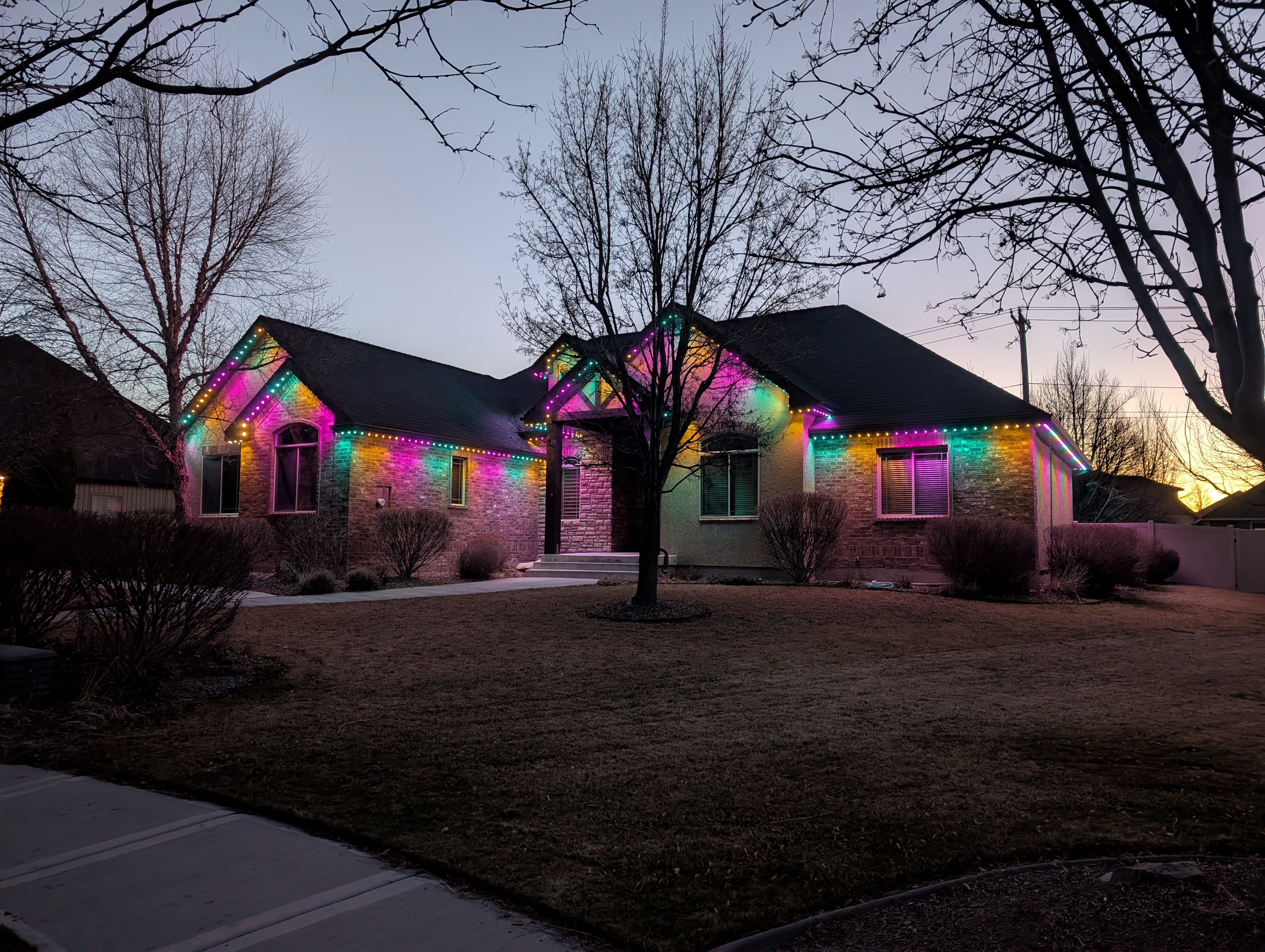 Home with colorful permanent LED exterior lighting at dusk