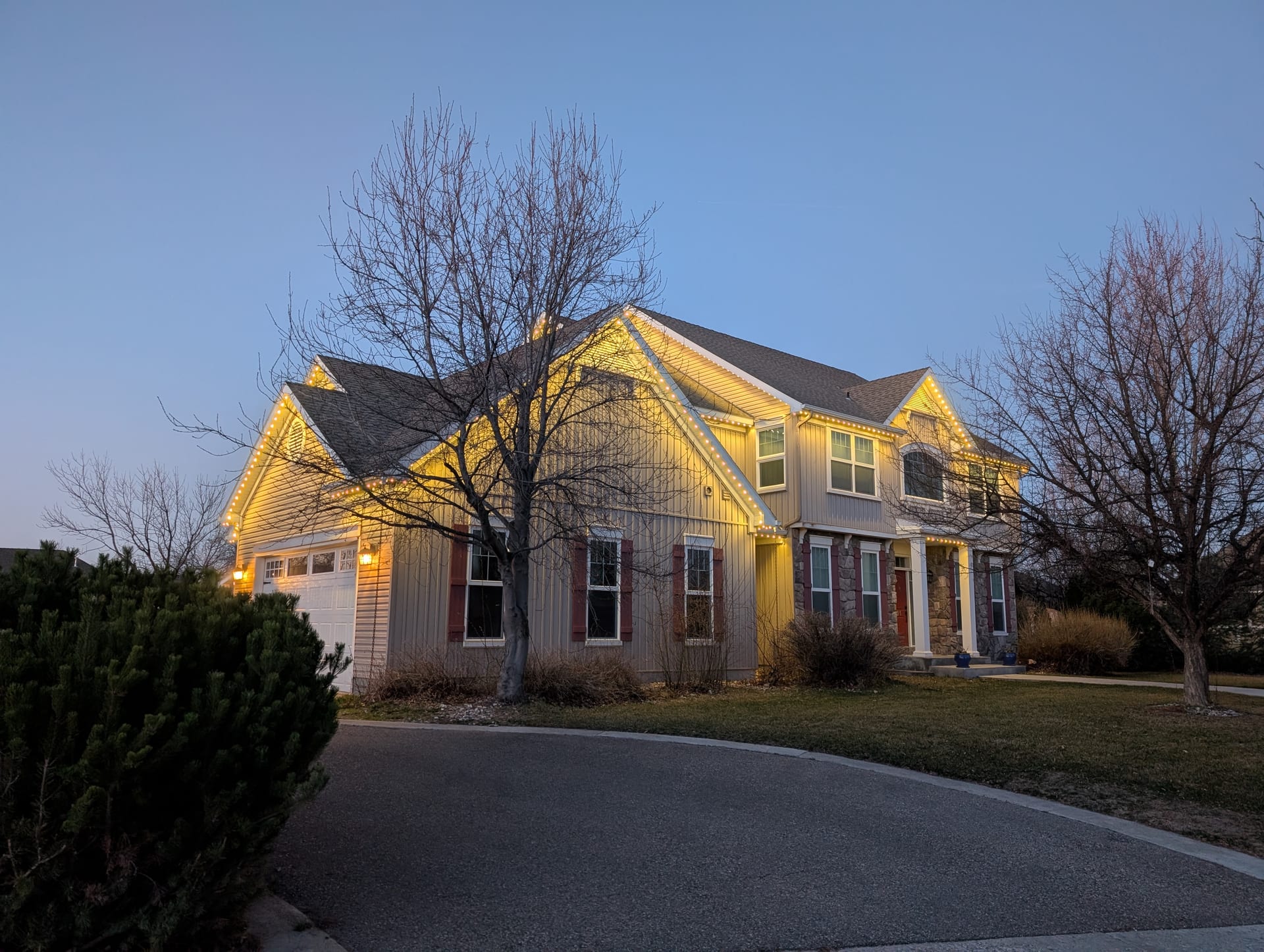 Warm white year-round permanent LED roofline lights on two-story home exterior